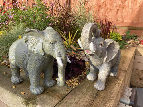 African and Lucky elephant garden ornament pair displayed on a wooden step